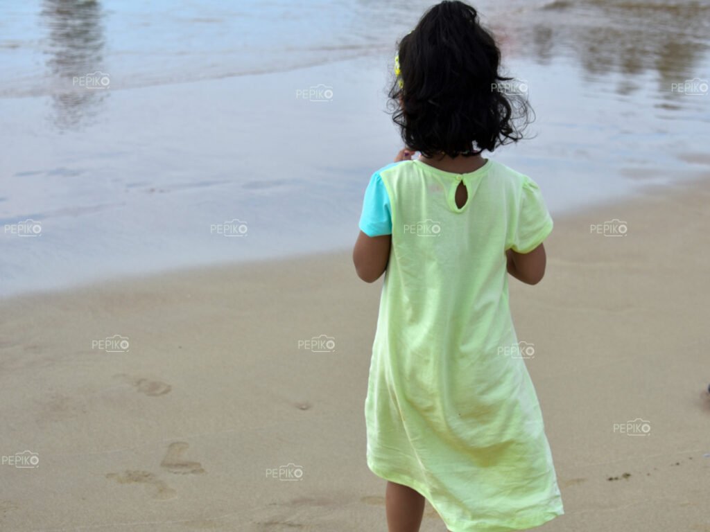 Beautiful pictures of old mature young child traveler in GOA in India enjoying at water sand beach