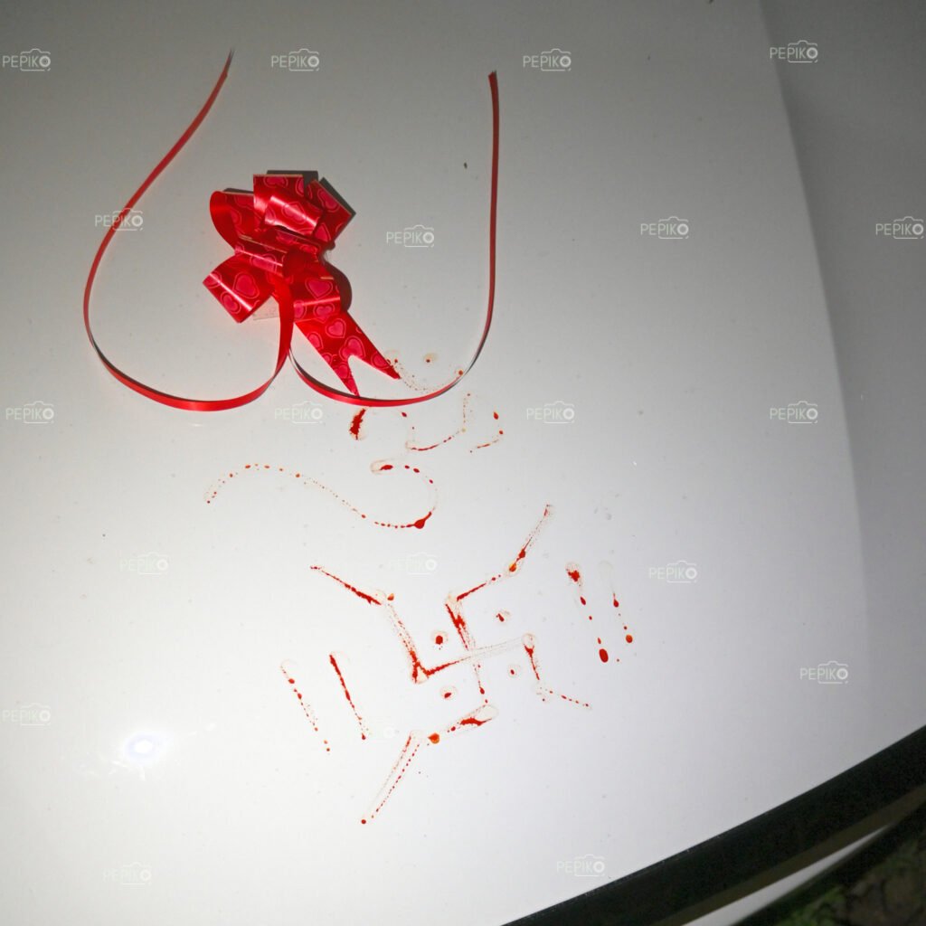 
									Picture of OM and Swastika sign on new white car front