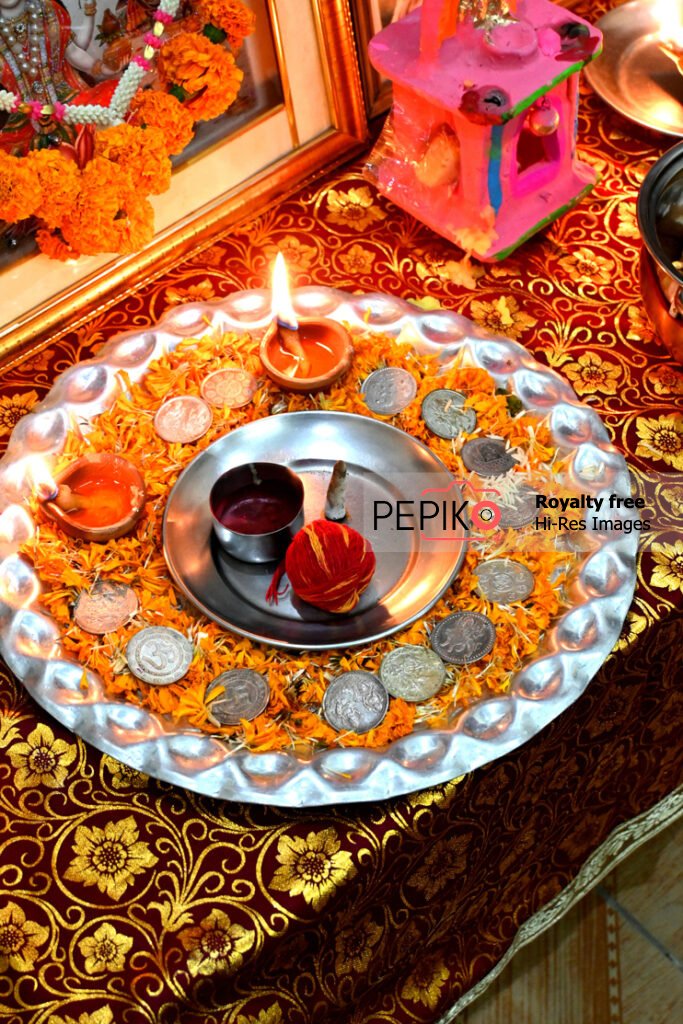 Silver plate loaded with silver coins and yellow flowers for festivals