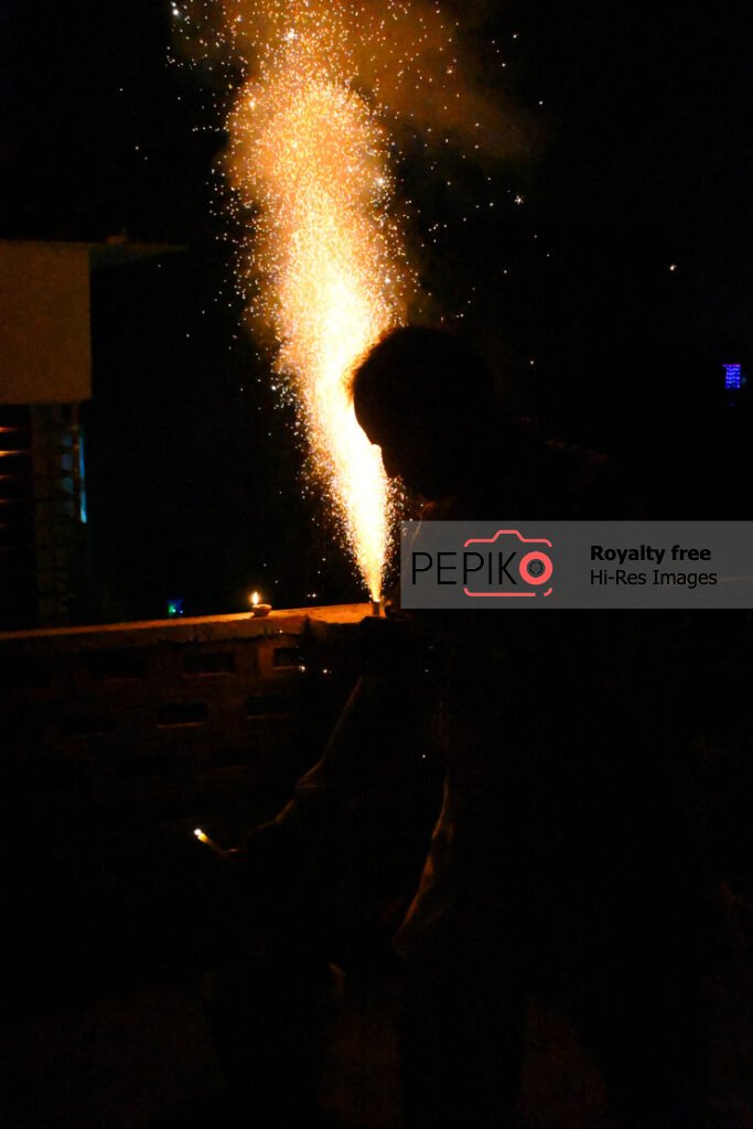 Beautiful picture of a man cracking crackers on diwali